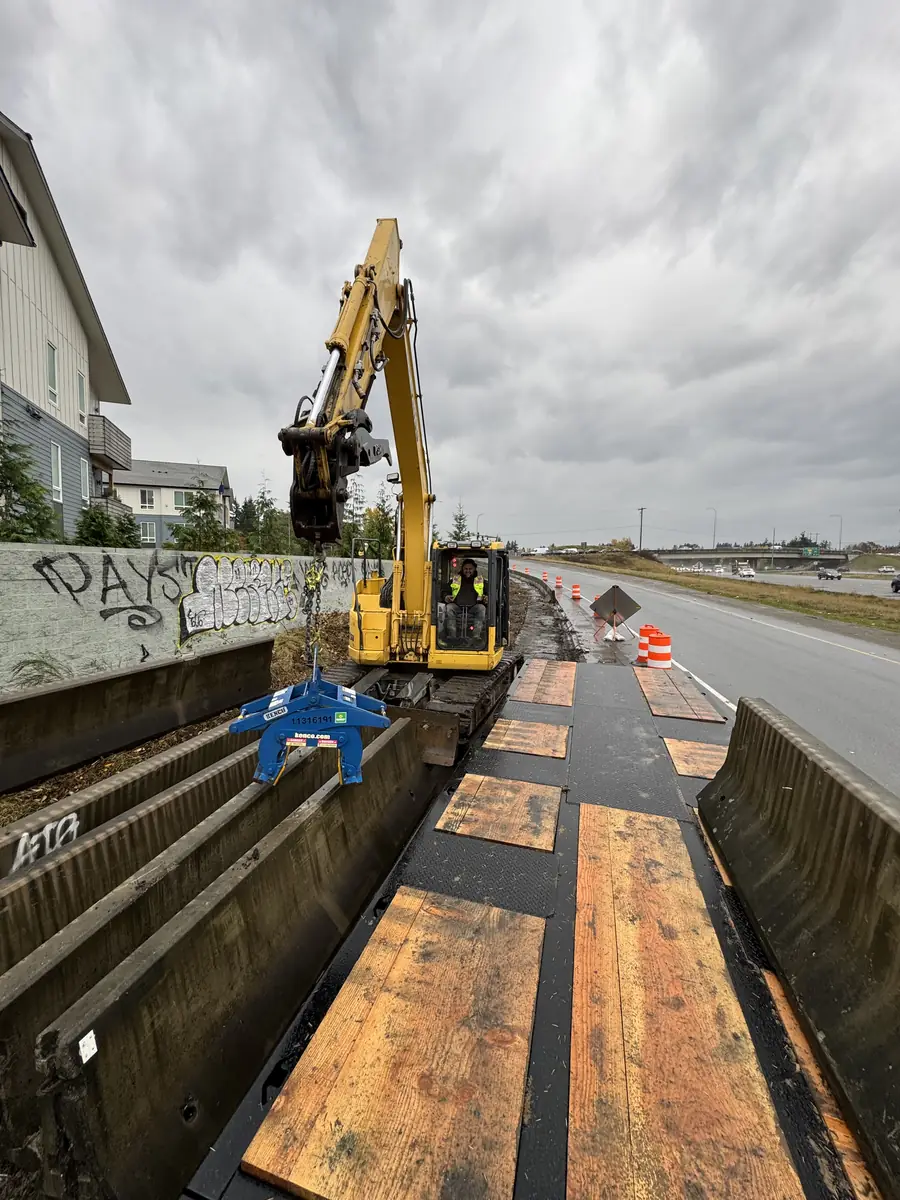 Setting concrete barrier on a highway shoulder