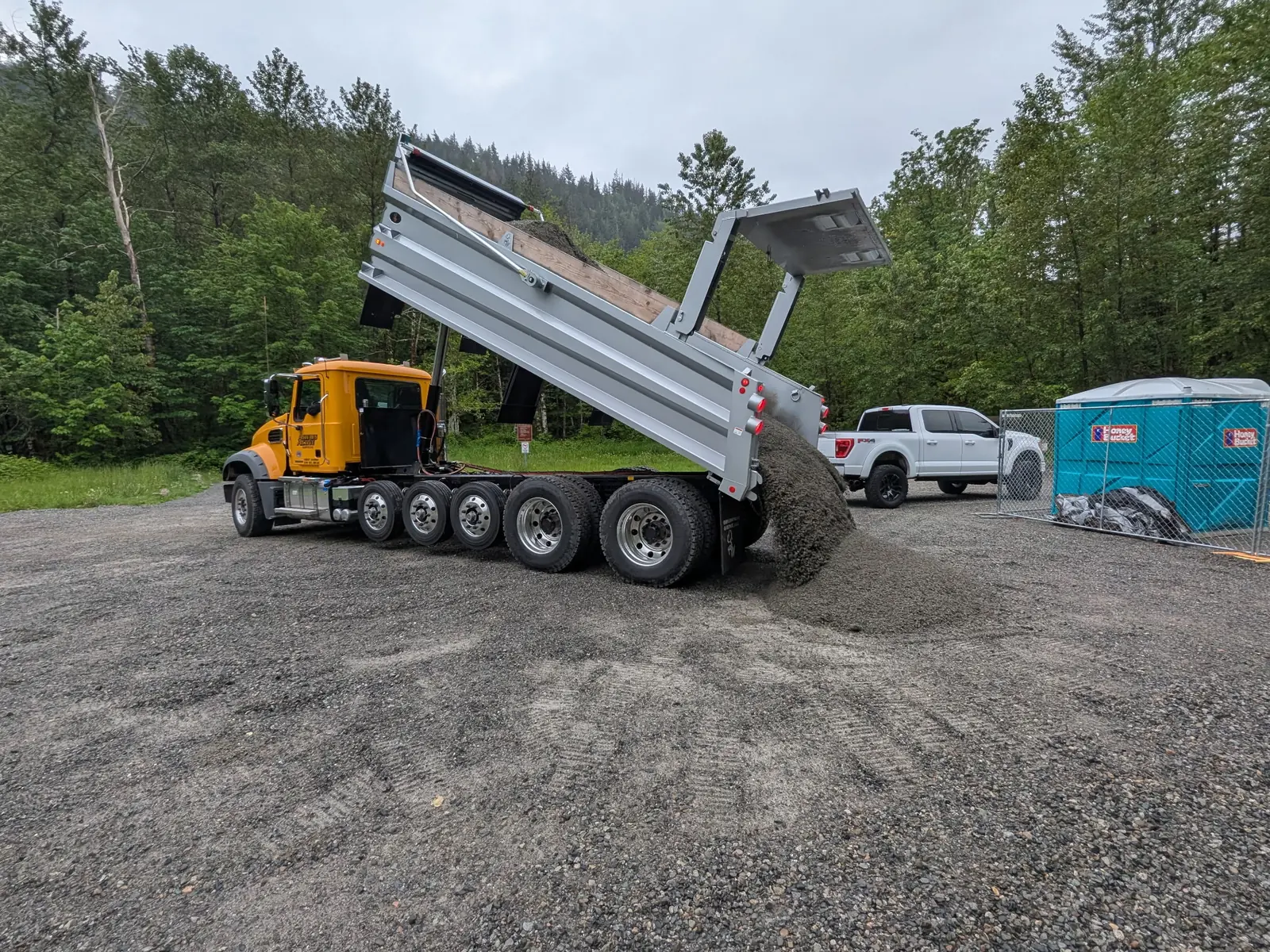Always Active dump truck unloading a truckload of gravel